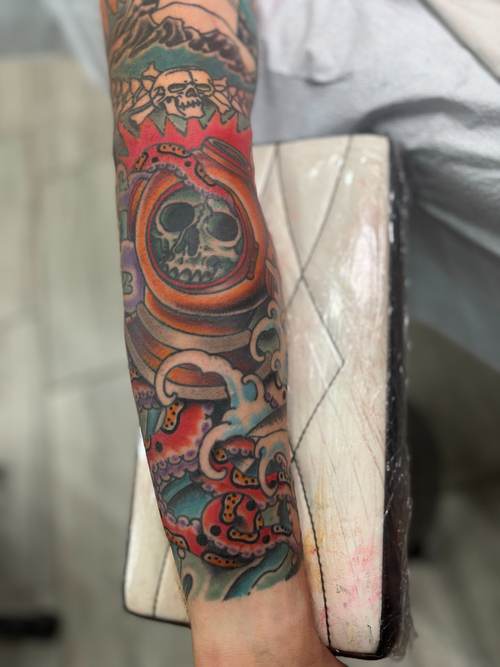 Color forearm tattoo with a skull inside a helmet